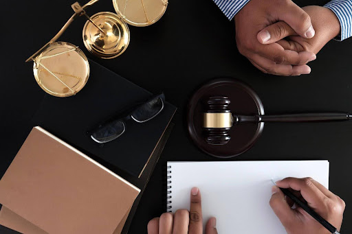 A defendant sits with his attorney discussing his rights to a speedy trial during the appellate process.